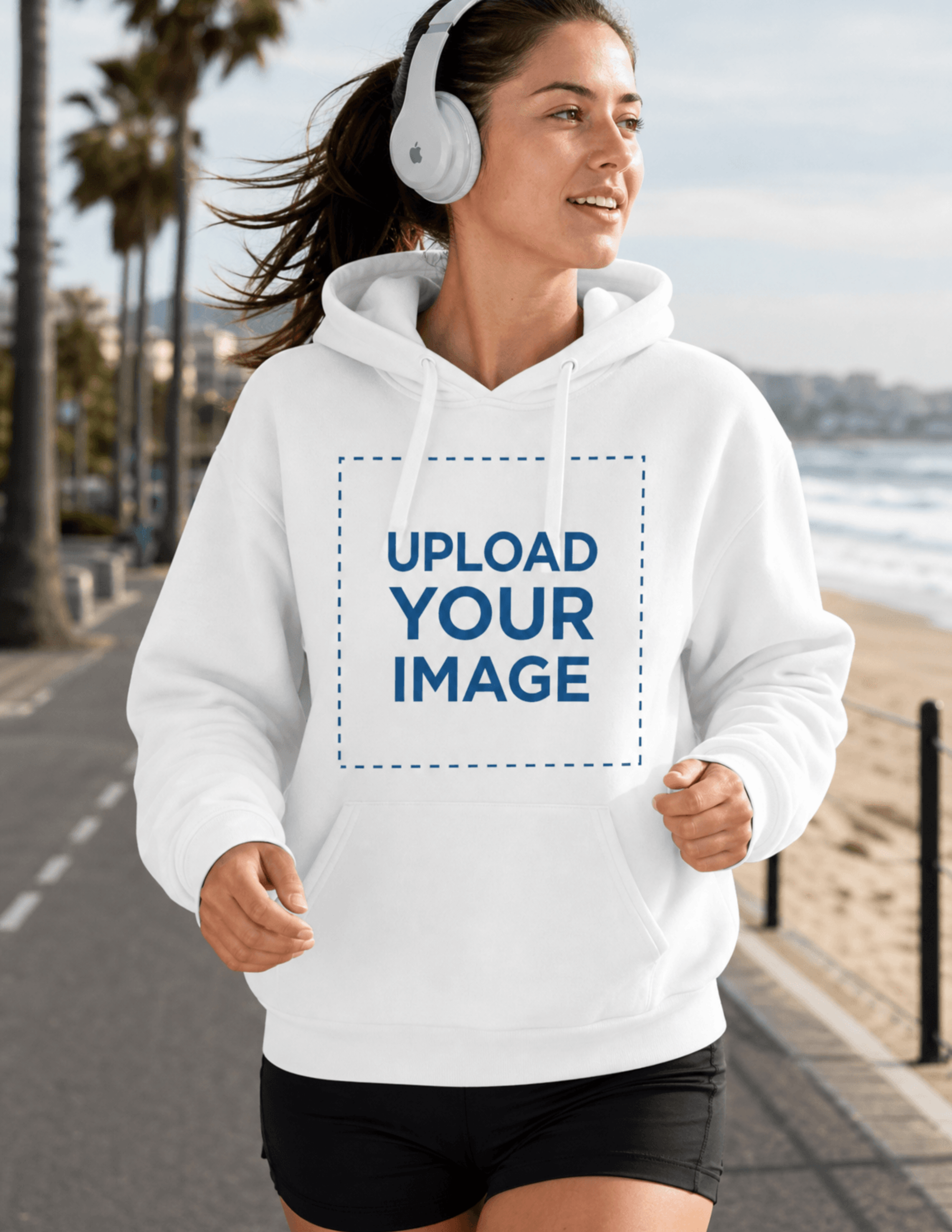 Free Woman with Headphones Running on the Street Wearing Hoodie Mockup Template to Edit Online