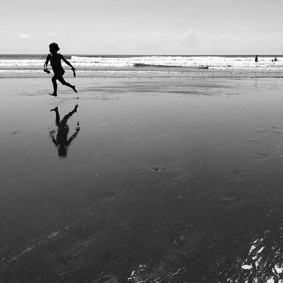 kid running on beach reflective photography