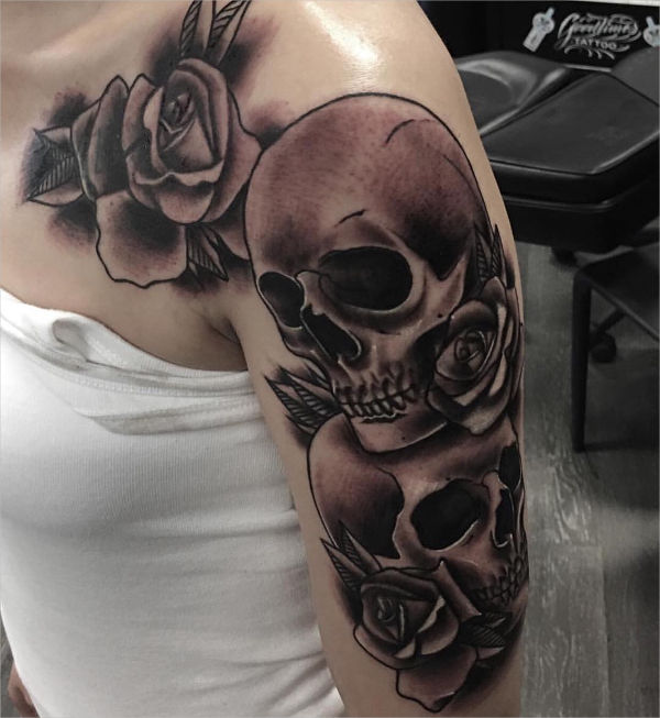 Colored traditional skull with flowers tattoo on inner arm